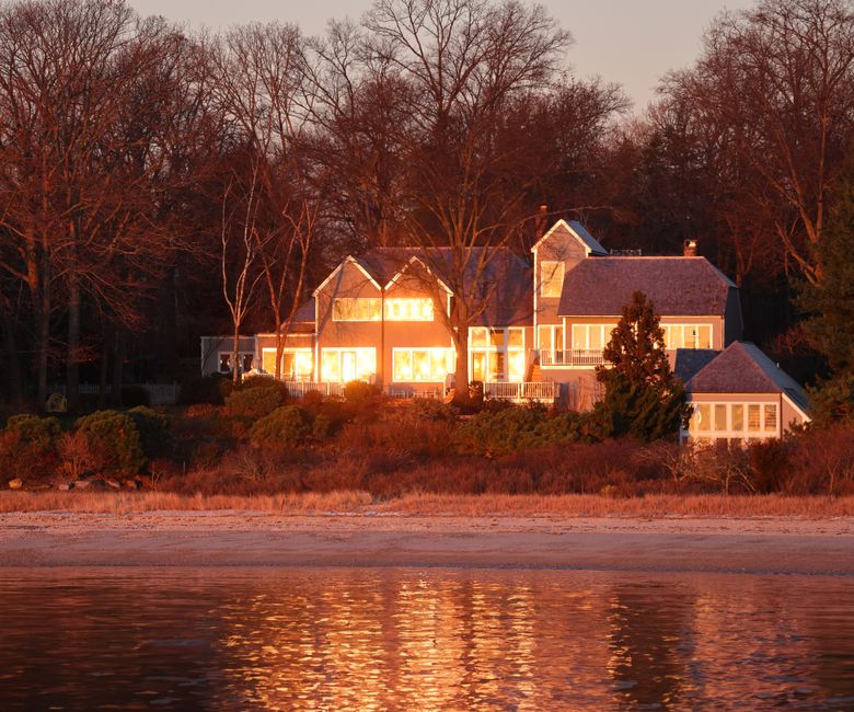 The sleek, modern exterior of a Georgia home at dusk, with interior lights creating a warm glow, symbolizing the integration of smart AI technology in real estate.