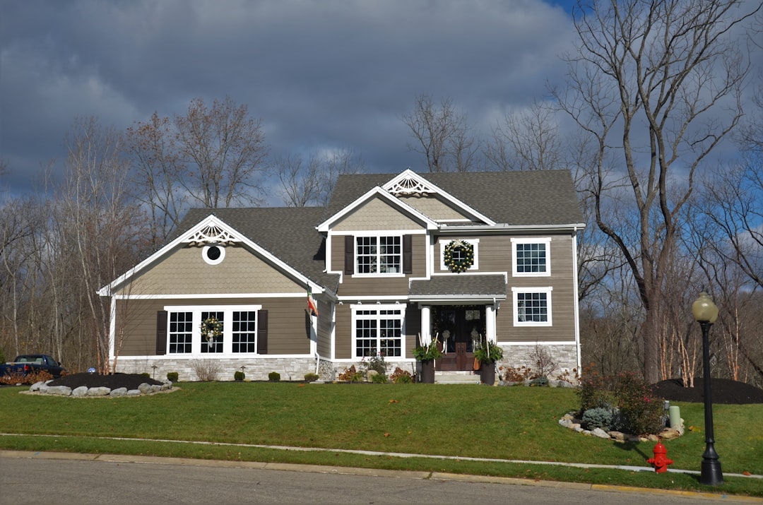A 'SOLD' sign proudly displayed in the front yard of a stunning, modern suburban home, symbolizing a successful and profitable real estate transaction.