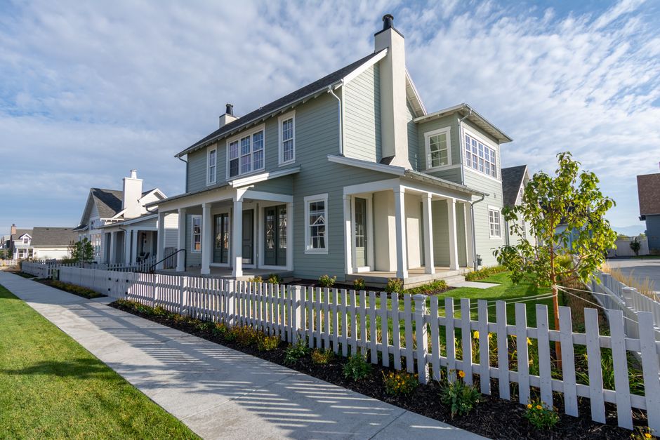 The beautiful exterior of a modern suburban home in Georgia on a bright, sunny day, featuring a well-manicured lawn and a welcoming front porch.