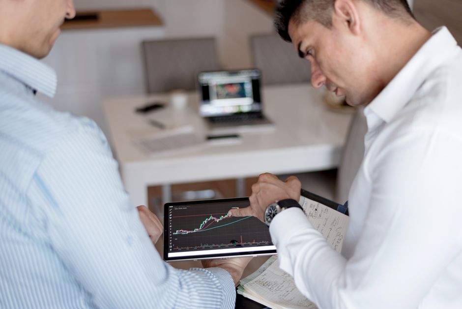 A professional real estate agent in a bright, modern setting, analyzing market data and charts on a digital tablet, showcasing a tech-forward strategy.